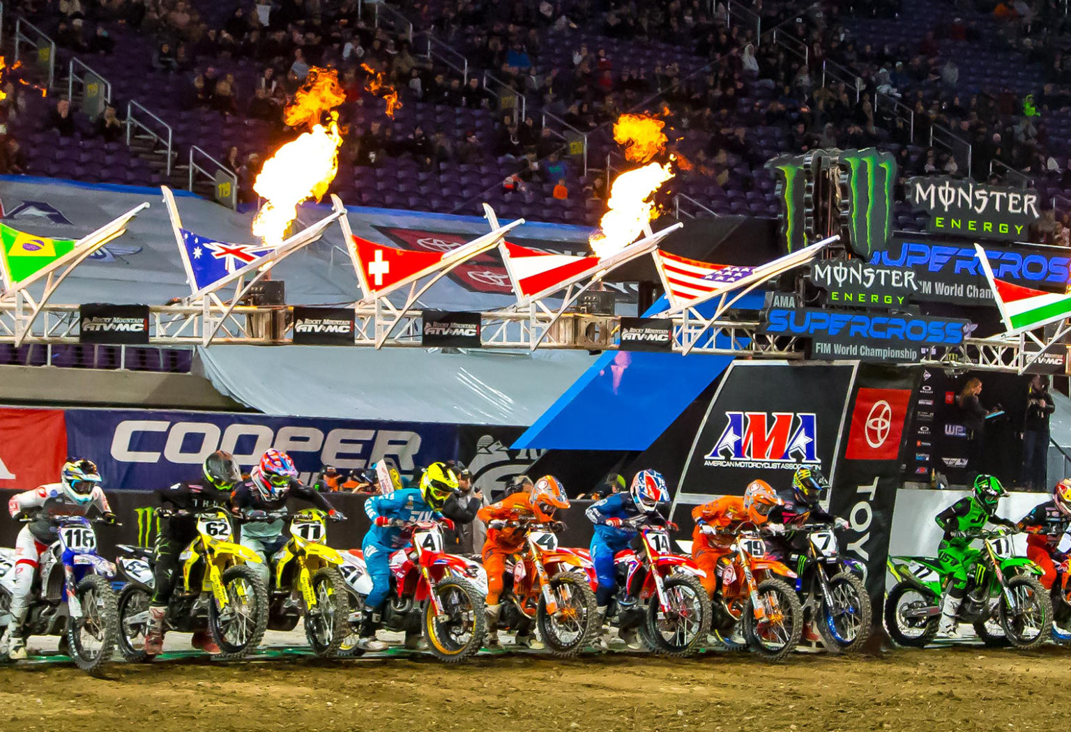 Supercross starting line full of colorful racers.