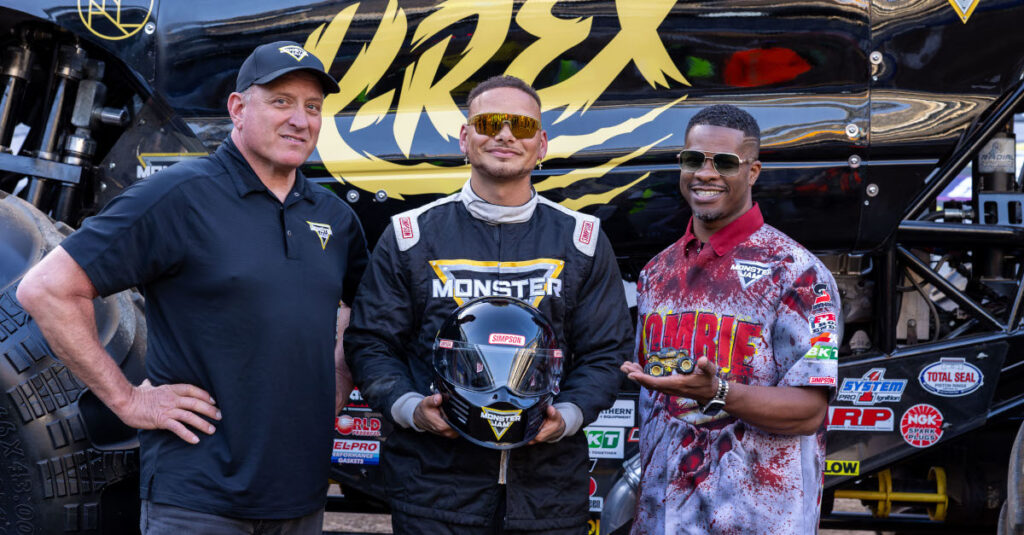 Tom Meents, Kane Brown and Bari Musawwir stand in front of the K-rex Monster Jam truck
