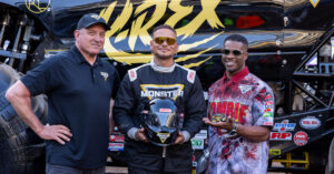 Tom Meents, Kane Brown and Bari Musawwir stand in front of the K-rex Monster Jam truck