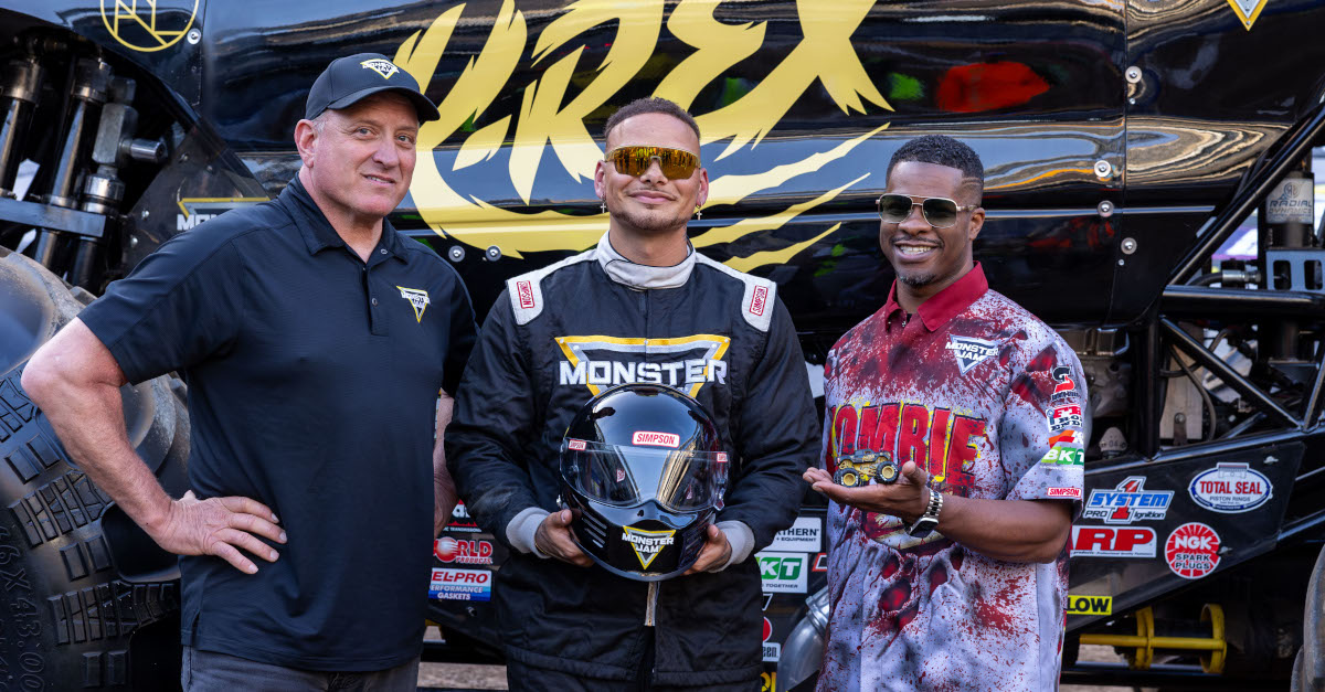 Tom Meents, Kane Brown and Bari Musawwir stand in front of the K-rex Monster Jam truck
